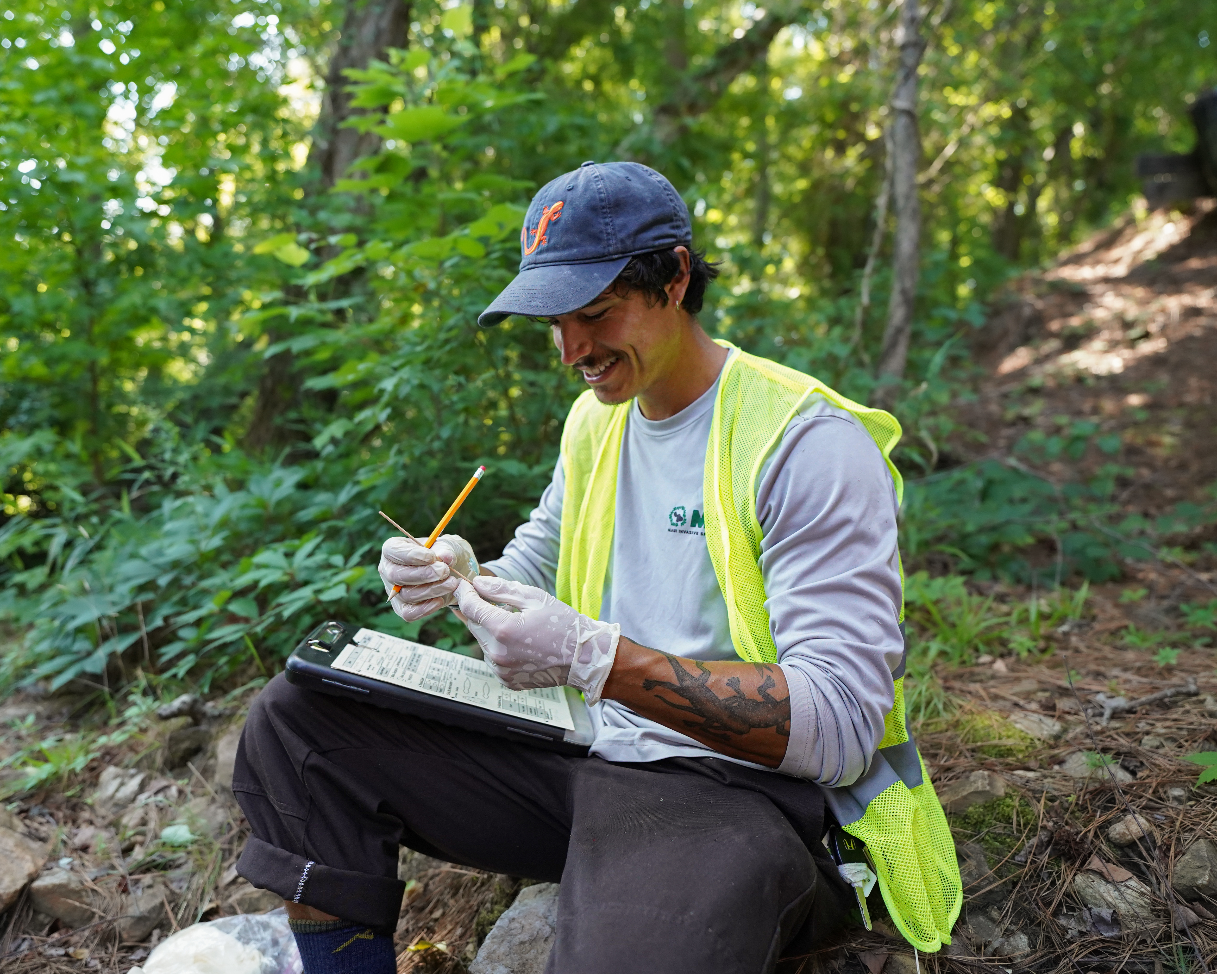 A snake in the foreground as Cory collects skin swabs